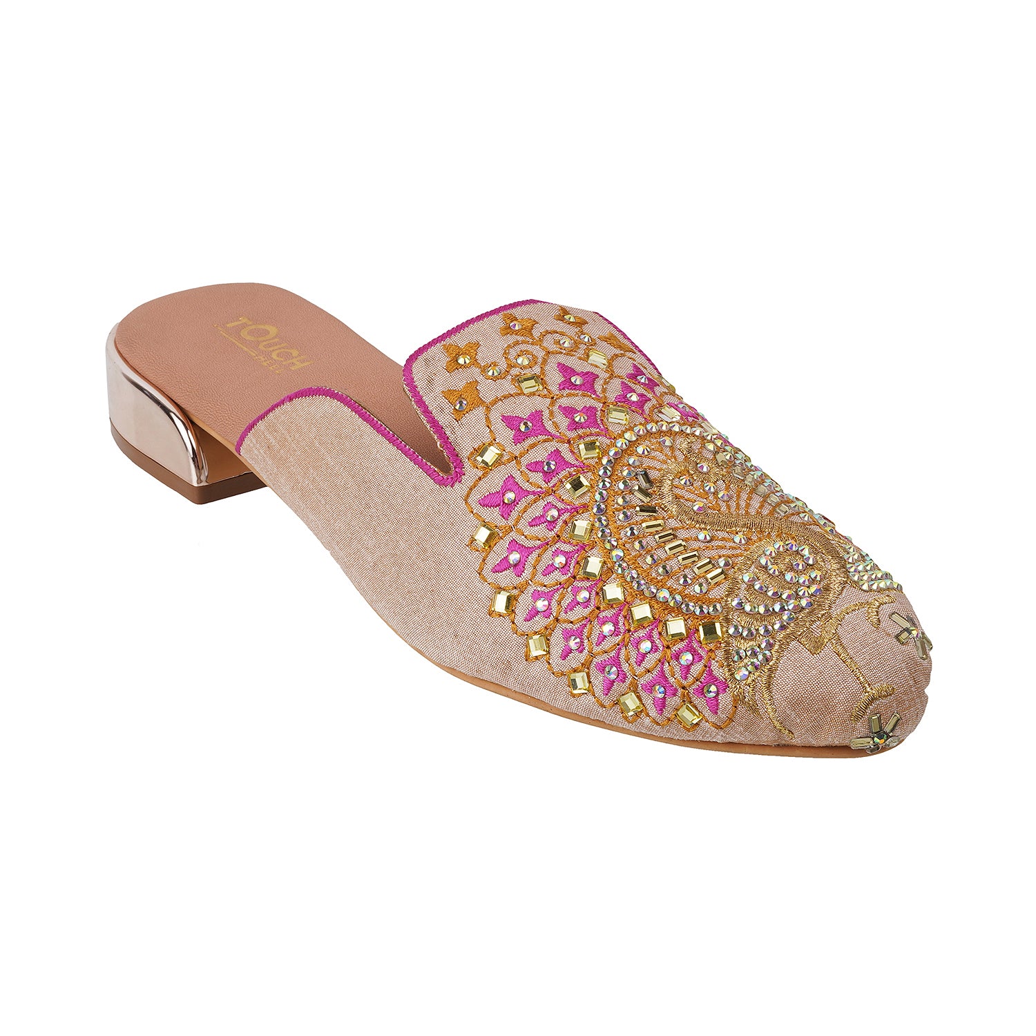 Elegant peacock embroidered mule juttis with ornate gold and pink detailing on a beige background.